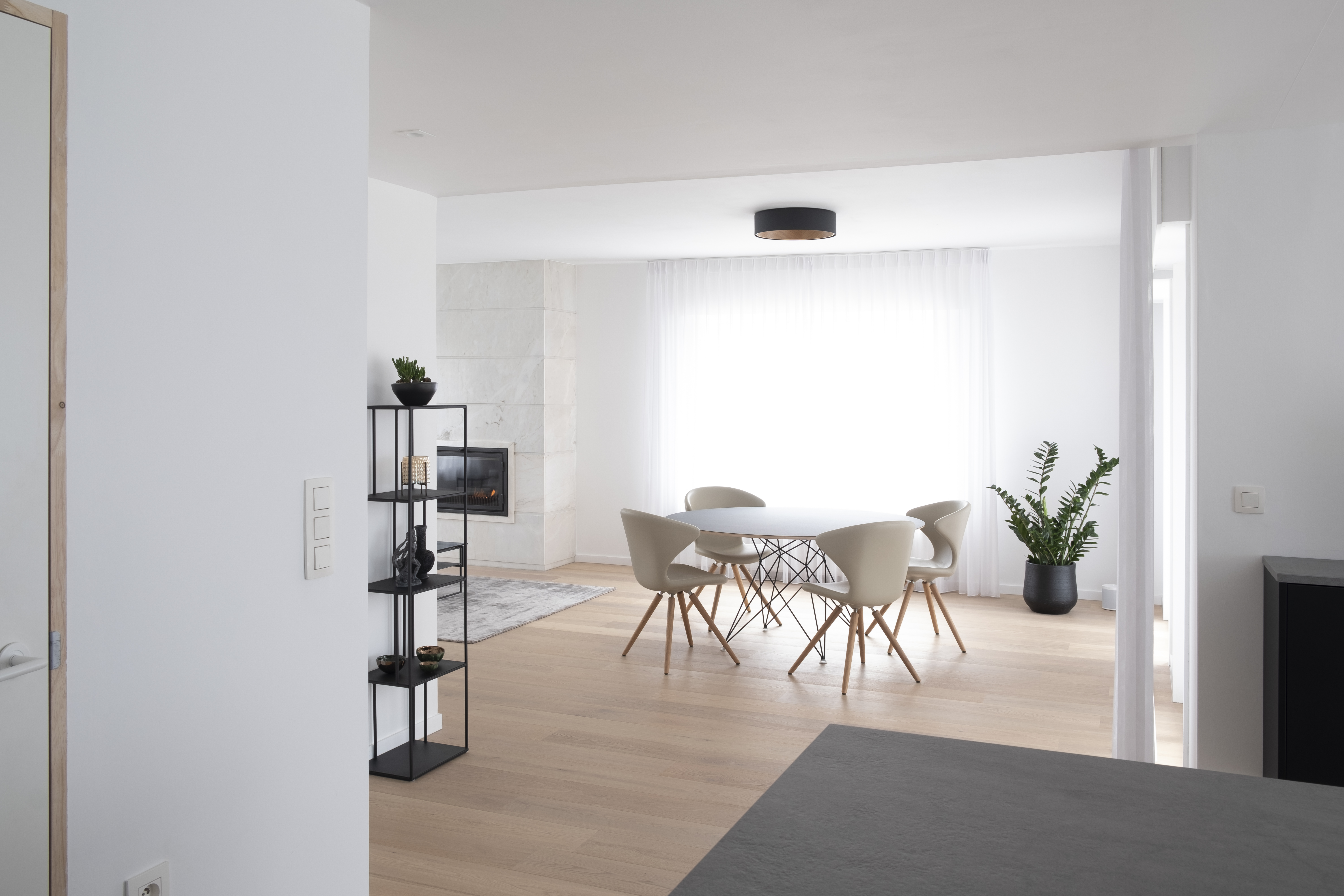 Een eetkamer in een moderne woning met parketvloer.
